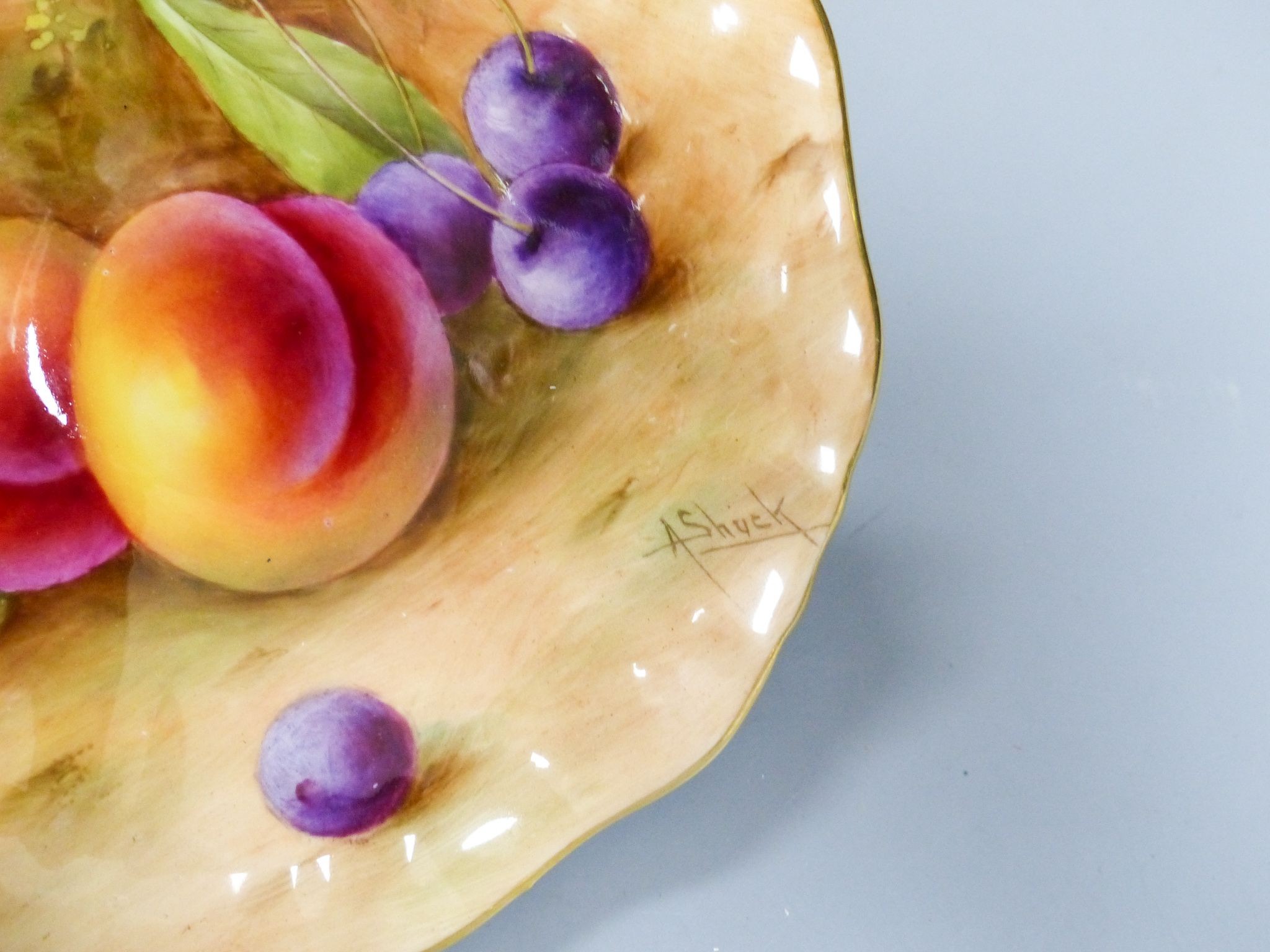 A Royal Worcester fruit painted pedestal dish signed A Shuck and a similar plate signed E Barnes, early 20th century, 14.3 and 16cm